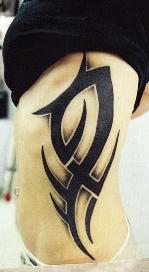 Black and gray tribal on ribs by Greg Drake: TattooNOW